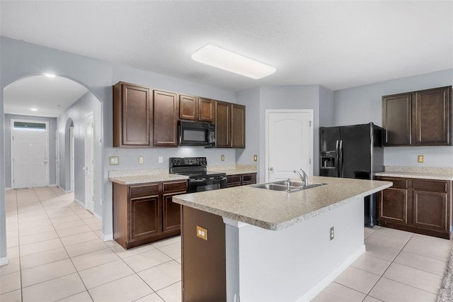 kitchen with an island with sink, sink, dark brown cabinetry, and black appliances