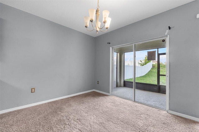 carpeted empty room featuring a notable chandelier