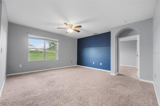 carpeted spare room featuring a textured ceiling and ceiling fan