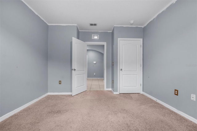 unfurnished bedroom with crown molding and light carpet