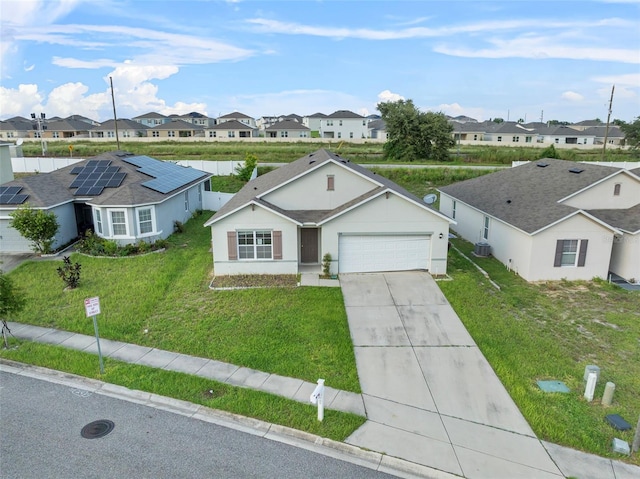 single story home with a garage, a front yard, and solar panels