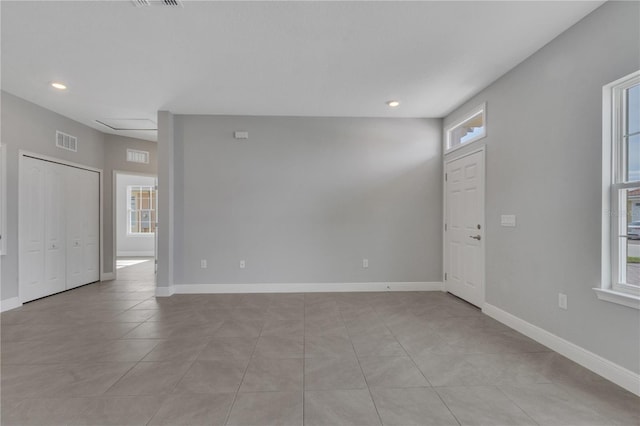 tiled empty room featuring plenty of natural light