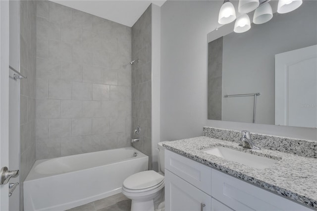 full bathroom with tile patterned flooring, tiled shower / bath, vanity, and toilet