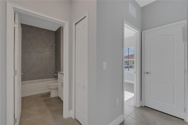 hall with light tile patterned floors