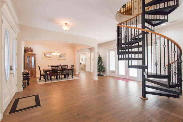 entryway featuring wood-type flooring, an inviting chandelier, and ornamental molding