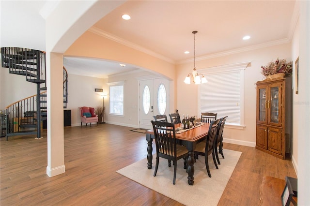 dining room with wood-type flooring, crown molding, and a chandelier