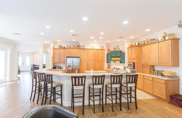 kitchen with appliances with stainless steel finishes, light hardwood / wood-style flooring, and crown molding