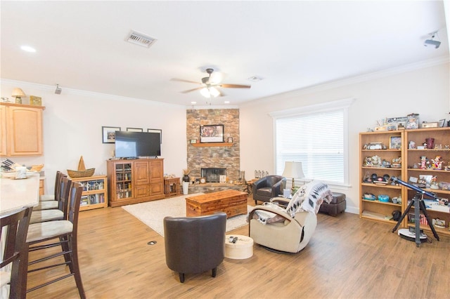 living room featuring a fireplace, ceiling fan, light hardwood / wood-style flooring, and ornamental molding