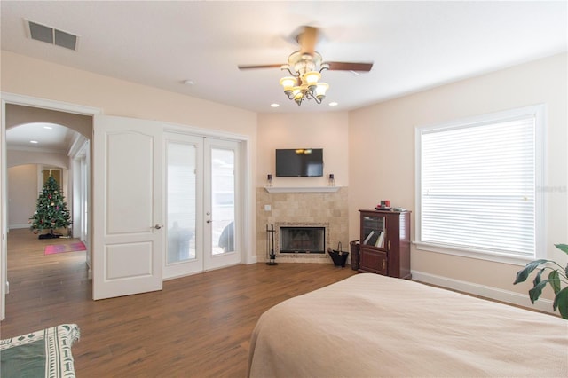 bedroom featuring ceiling fan, dark wood-type flooring, access to outside, and multiple windows