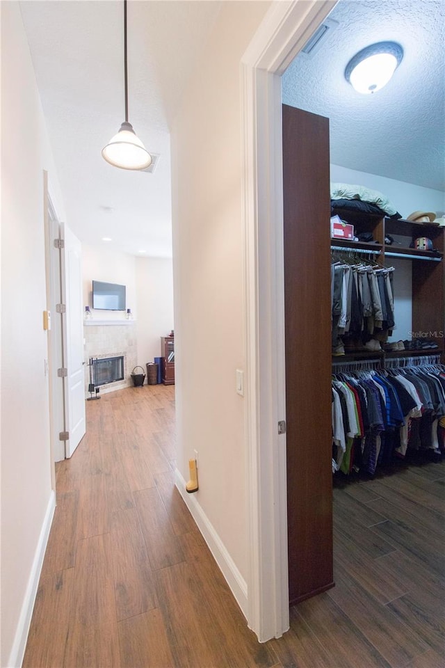 corridor featuring a textured ceiling and hardwood / wood-style flooring