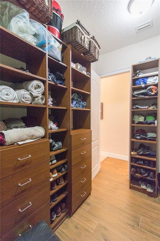 spacious closet with light hardwood / wood-style flooring