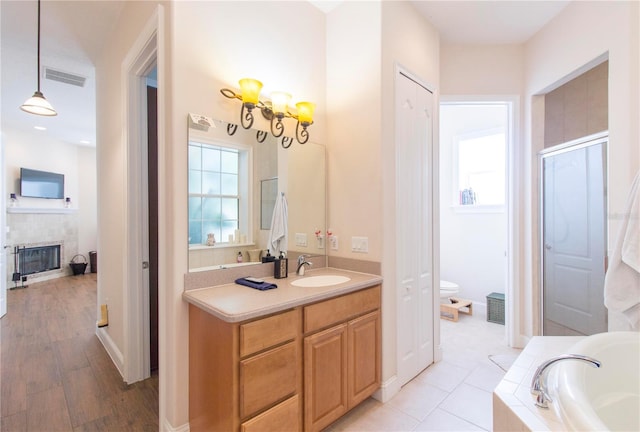 full bathroom featuring vanity, hardwood / wood-style flooring, toilet, and separate shower and tub