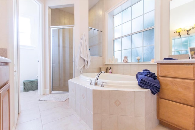 bathroom featuring plus walk in shower, vanity, and tile patterned flooring