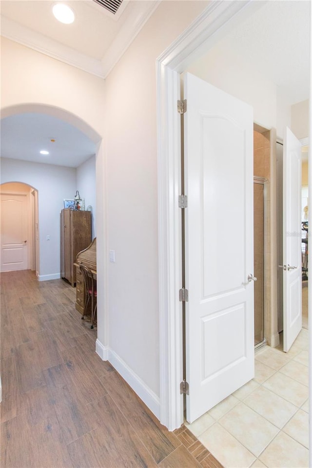 hall featuring crown molding and light hardwood / wood-style flooring