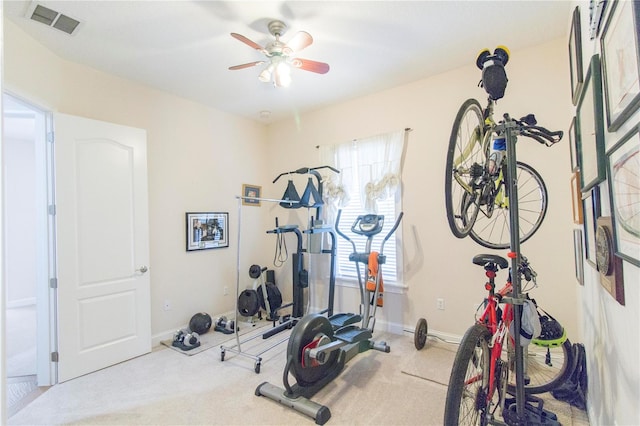 workout room with ceiling fan and light colored carpet