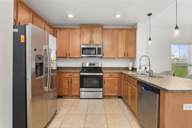 kitchen with pendant lighting, light tile patterned flooring, sink, kitchen peninsula, and appliances with stainless steel finishes