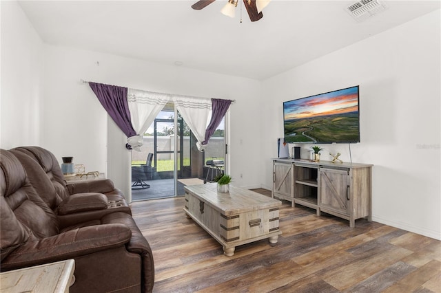 living room featuring ceiling fan and dark wood-type flooring