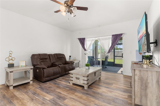 living room featuring dark wood-type flooring and ceiling fan