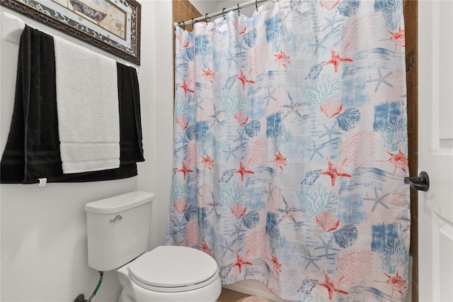 bathroom with toilet and a shower with shower curtain