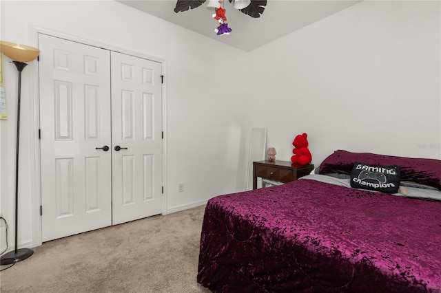 carpeted bedroom with ceiling fan and a closet