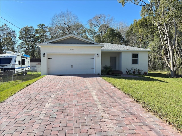 ranch-style home featuring a garage and a front lawn