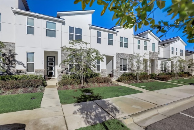 1842 Tropical Palms Cir, Kissimmee, FL 34747 - view of property with stone siding, stucco siding, a front yard, and a residential view