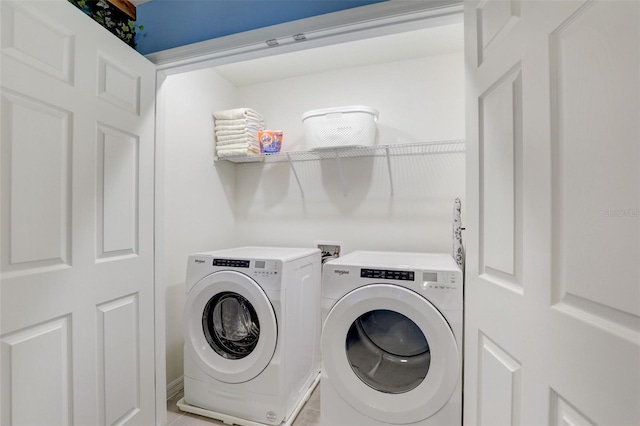 clothes washing area featuring light tile patterned flooring and washing machine and clothes dryer