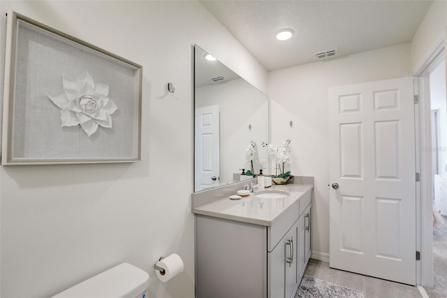 bathroom featuring vanity, tile patterned floors, and toilet