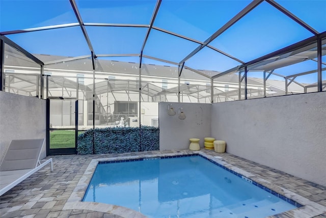 view of swimming pool featuring a lanai and a patio