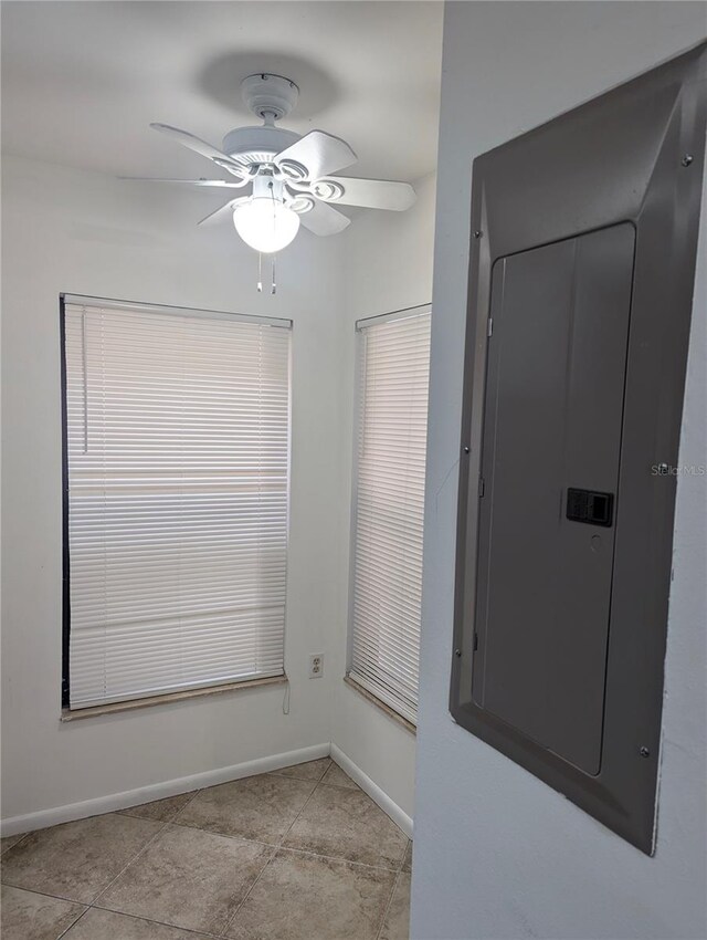 unfurnished room with ceiling fan, electric panel, and light tile patterned flooring