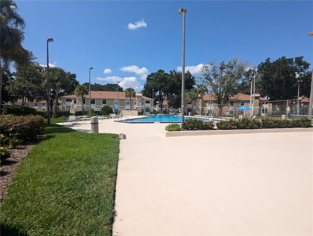 view of swimming pool featuring a yard and a patio area