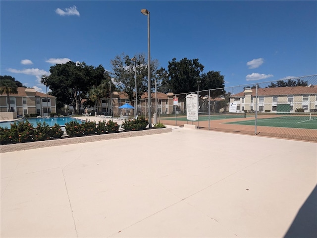 view of home's community featuring tennis court and a swimming pool