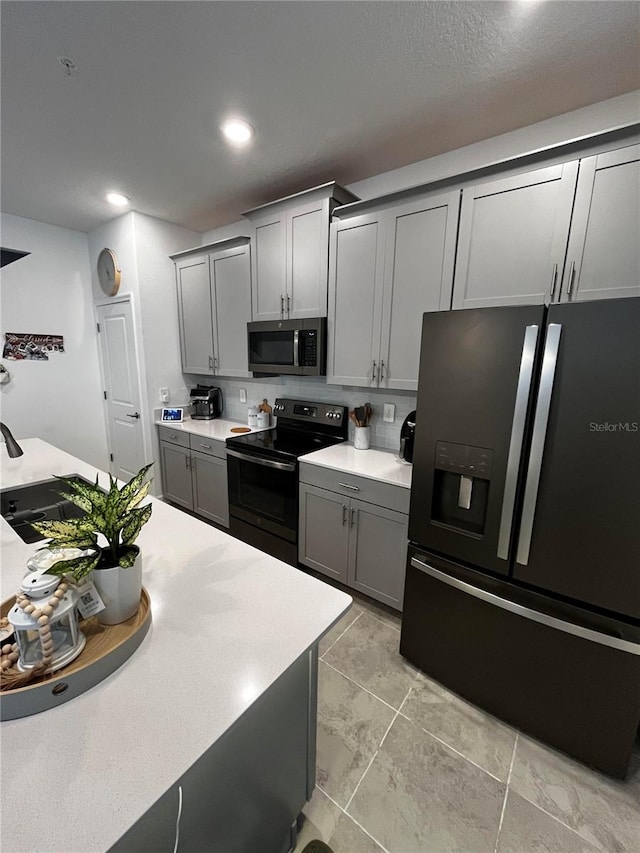 kitchen featuring gray cabinets and appliances with stainless steel finishes