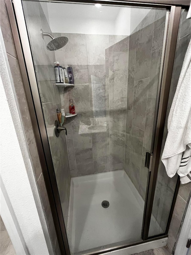 bathroom featuring a shower with door