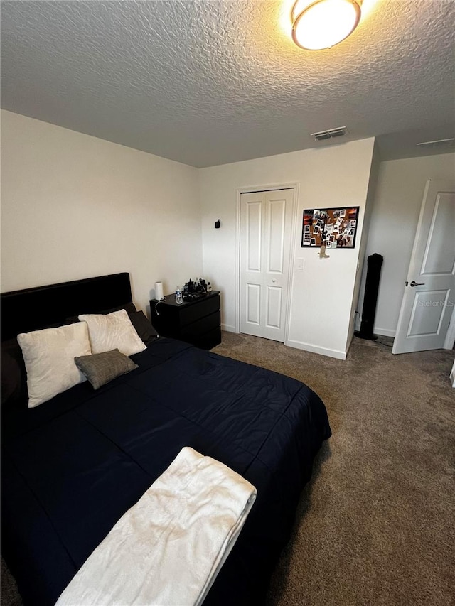 carpeted bedroom with a textured ceiling and a closet