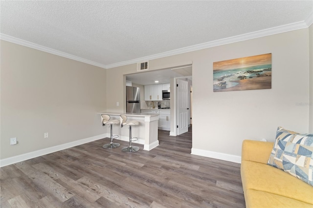 interior space featuring a textured ceiling, crown molding, and dark wood-type flooring