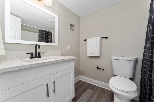 bathroom with vanity, toilet, and hardwood / wood-style flooring