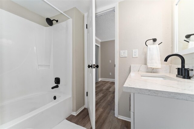 bathroom with vanity, bathing tub / shower combination, a textured ceiling, and hardwood / wood-style flooring