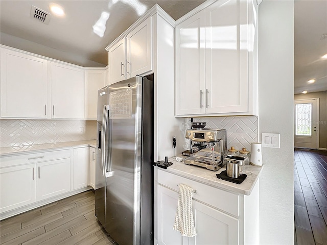 kitchen featuring decorative backsplash, light wood-type flooring, white cabinetry, and stainless steel fridge with ice dispenser