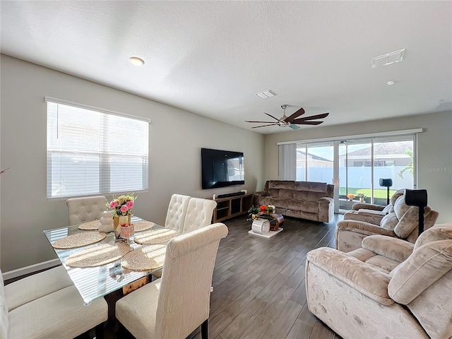 living room with ceiling fan, a textured ceiling, and dark hardwood / wood-style floors