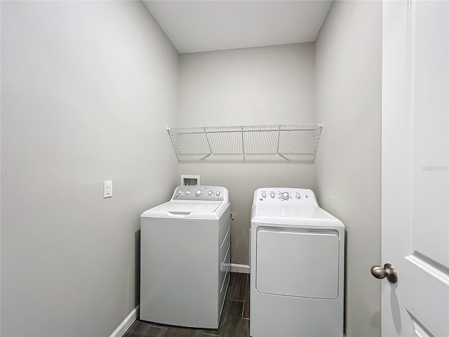 clothes washing area with dark hardwood / wood-style floors and washer and dryer