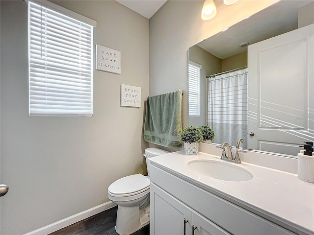 bathroom with hardwood / wood-style floors, vanity, and toilet