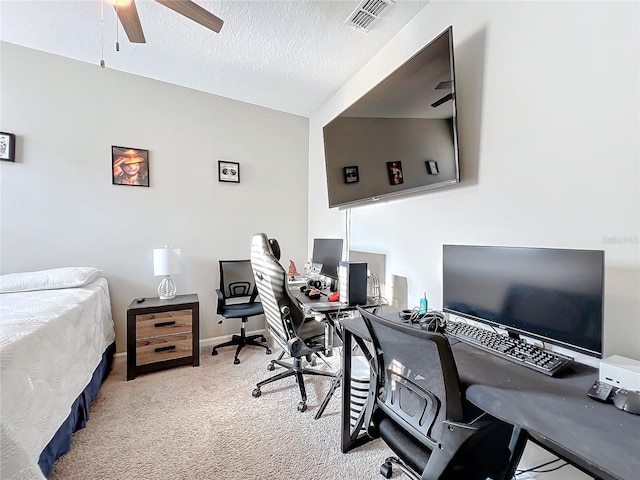 carpeted office space featuring a textured ceiling and ceiling fan