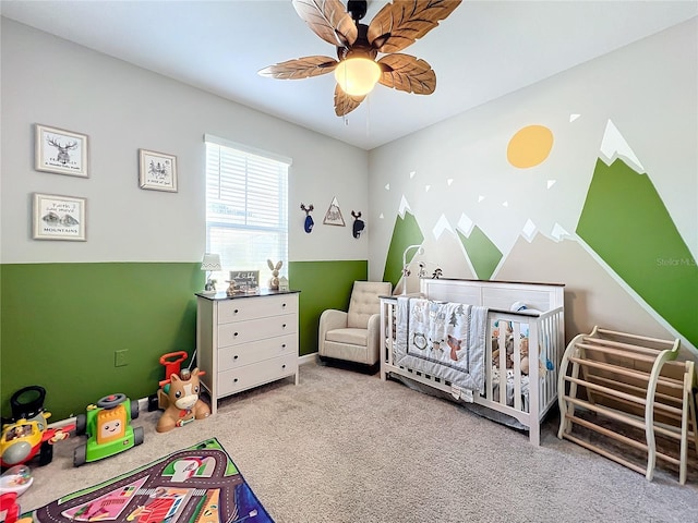 bedroom featuring a crib, carpet flooring, and ceiling fan