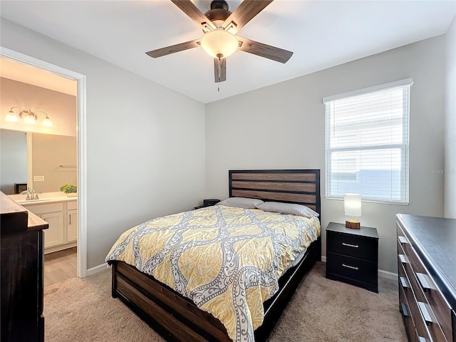 carpeted bedroom featuring ensuite bath, ceiling fan, and sink