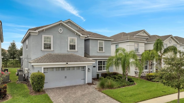 1536 Maidstone Ct, Davenport, FL 33896 - traditional-style house featuring a front yard, decorative driveway, a tiled roof, and stucco siding