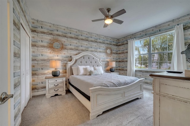 carpeted bedroom with wood walls and ceiling fan