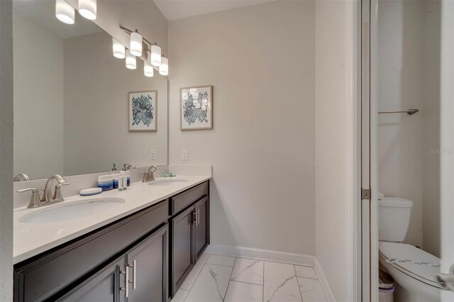 1536 Maidstone Ct, Davenport, FL 33896 - full bathroom with marble finish floor, a sink, toilet, and baseboards