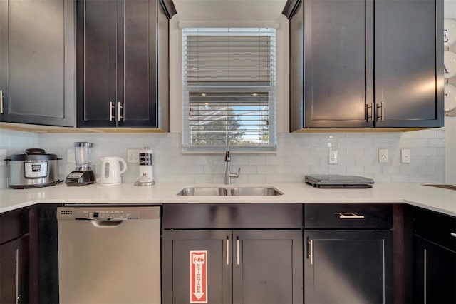 kitchen featuring decorative backsplash, dishwasher, and sink