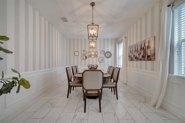 1536 Maidstone Ct, Davenport, FL 33896 - dining space with marble finish floor, wallpapered walls, a chandelier, and visible vents